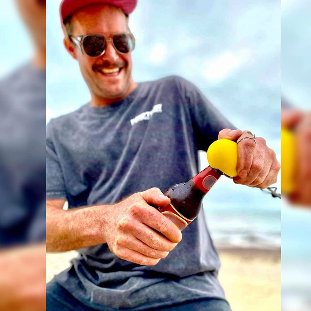 Fisher using the Original IkiPik fish spike bottle opener to open a beer after  dispatching a freshly caught fish